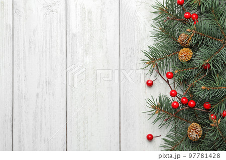 Flat lay composition with fir branches and berries on white wooden background, space for text. Winter holidays Flat lay composition with fir branches and berries on white wooden background, space for text. Winter holidays 97781428