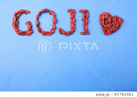 Word GOJI and heart made of dried berries on blue background, flat lay. Space for text Word GOJI and heart made of dried berries on blue background, flat lay. Space for text 97781461