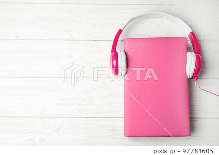 Book and headphones on white wooden background, flat lay. Space for text 97781605