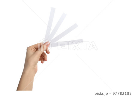 Woman holding perfume testing strips on white background, closeup Woman holding perfume testing strips on white background, closeup 97782185