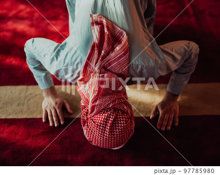 A Muslim praying in a modern mosque during the holy Muslim month of Ramadan 97785980