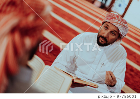 A group of Muslims reading the holy book of the Quran in a modern mosque during the Muslim holiday of Ramadan A group of Muslims reading the holy book of the Quran in a modern mosque during the Muslim holiday of Ramadan 97786001