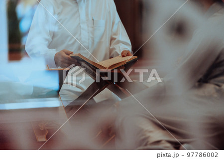 A group of Muslims reading the holy book of the Quran in a modern mosque during the Muslim holiday of Ramadan A group of Muslims reading the holy book of the Quran in a modern mosque during the Muslim holiday of Ramadan 97786002