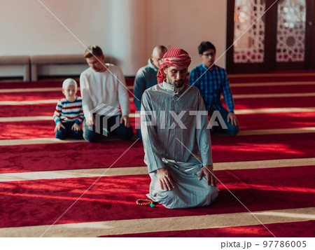 A group of Muslims in a modern mosque praying the Muslim prayer namaz, during the holy month of Ramadan 97786005
