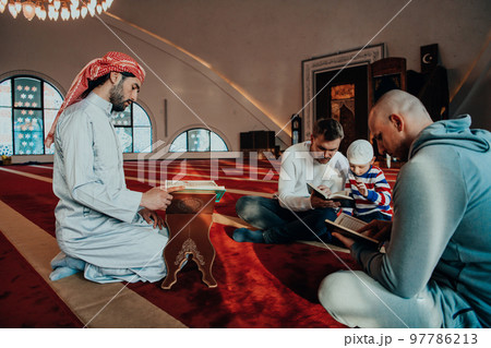 A group of Muslims reading the holy book of the Quran in a modern mosque during the Muslim holiday of Ramadan A group of Muslims reading the holy book of the Quran in a modern mosque during the Muslim holiday of Ramadan 97786213