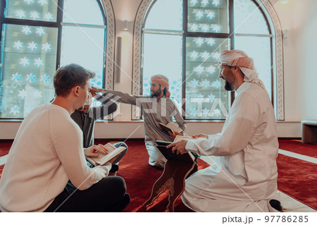 A group of Muslims reading the holy book of the Quran in a modern mosque during the Muslim holiday of Ramadan A group of Muslims reading the holy book of the Quran in a modern mosque during the Muslim holiday of Ramadan 97786285