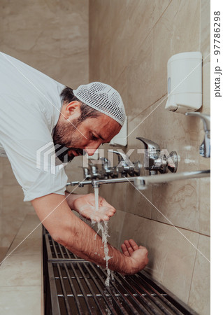 A Muslim performing ablution. Ritual religious cleansing of Muslims before performing prayer. The process of cleansing the body before prayer 97786298