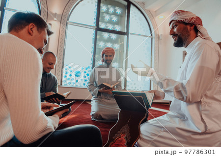 A group of Muslims reading the holy book of the Quran in a modern mosque during the Muslim holiday of Ramadan 97786301
