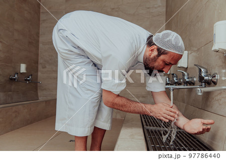 A Muslim performing ablution. Ritual religious cleansing of Muslims before performing prayer. The process of cleansing the body before prayer 97786440