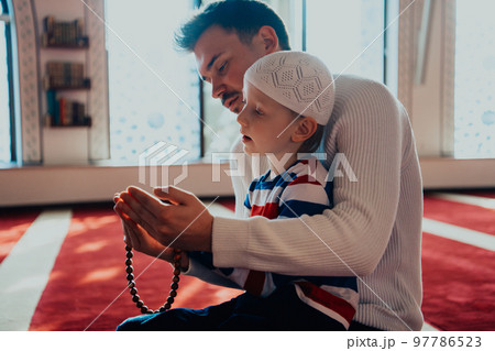 Muslim prayer father and son in mosque prayingtogether Muslim prayer father and son in mosque prayingtogether 97786523