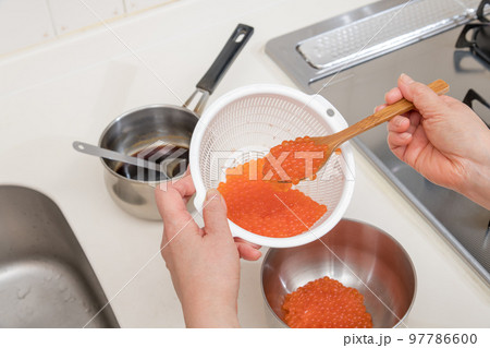 【イクラの醤油漬けを作るために、お酒が馴染んだ生イクラをボウルに移す】 【イクラの醤油漬けを作るために、お酒が馴染んだ生イクラをボウルに移す】 97786600