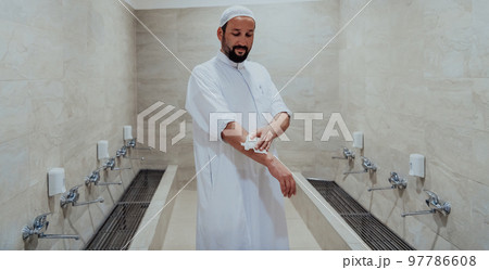 A portrait of a man in abdesthana using a towel A portrait of a man in abdesthana using a towel 97786608