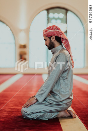 A Muslim praying in a modern mosque during the holy Muslim month of Ramadan A Muslim praying in a modern mosque during the holy Muslim month of Ramadan 97786668