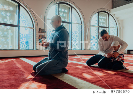 A group of Muslims in a modern mosque praying the Muslim prayer namaz, during the holy month of Ramadan A group of Muslims in a modern mosque praying the Muslim prayer namaz, during the holy month of Ramadan 97786670