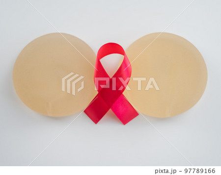 Breast implants and satin ribbon. Breast cancer awareness symbol. 97789166