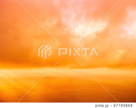 Aerial view red burning sunset over the sea with rocky volcanic cliff. Abstract nature summer sunset ocean sea background. Small waves on golden warm water surface Evening. Horizon. Nobody. No people. 97789868