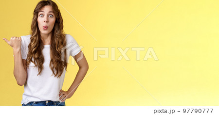 Cutrious interested excited attractive enthusiastic girl gossiping intrigued stare camera thrilled folding lips tempting admiration show thumb left impressive cool thing hold hand waist relaxed 97790777