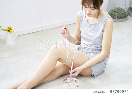 太ももをメジャーで測る女性 太ももをメジャーで測る女性 97790974