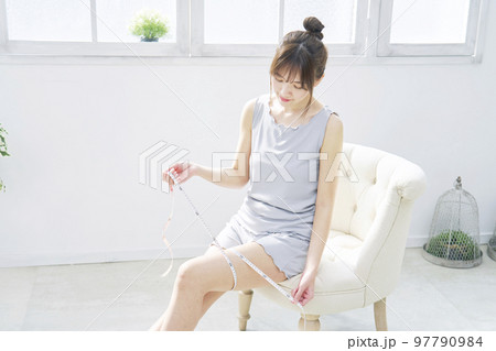 太ももをメジャーで測る女性 97790984