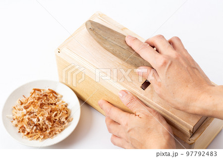 鰹節を削る女性の手元 97792483