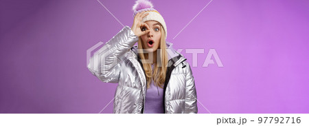 Fascinated amused young attractive blond girl vacation snowy country look astonished impressed show okay sign eye wow folding lips wearing stylish silver glittering jacket gasping amazed Fascinated amused young attractive blond girl vacation snowy country look astonished impressed show okay sign eye wow folding lips wearing stylish silver glittering jacket gasping amazed 97792716