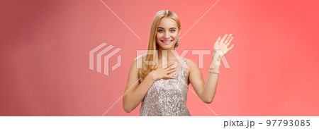 Happy blond girl say hi introduce herself boyfriend friends raise hand waving hello hi gesture press palm chest sincere smiling broadly tell truth swearing, promise keep secret friendly gaze camera 97793085