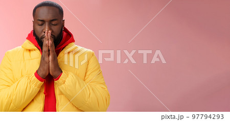 Serious-looking determined young focused african-american man prepare will important meeting press palms together hands pray close eyes supplicating praying make wish, standing pink background 97794293