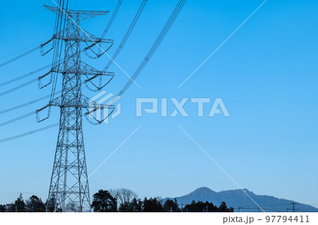青空の中の高圧電気鉄塔と筑波山 97794411