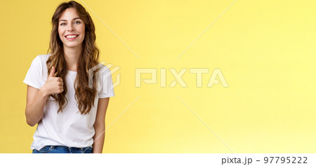Girl thinks you done great job. Smiling cheerful good-looking woman long curly haircut approve perfect choice give thumb up agree like your style grinning support excellent idea yellow background Girl thinks you done great job. Smiling cheerful good-looking woman long curly haircut approve perfect choice give thumb up agree like your style grinning support excellent idea yellow background 97795222