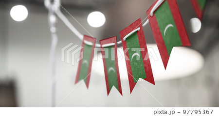 A garland of Maldives national flags on an abstract blurred background 97795367