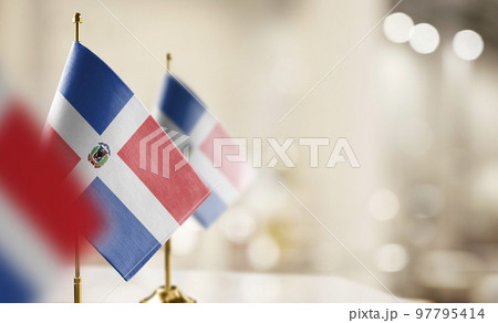 Small flags of the Dominicana on an abstract blurry background 97795414