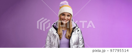 Cute young blond european woman wearing warm cozy jacket hat ski resort vacation having fun smiling amused rent equipment wanna learn snowboarding standing happily purple background 97795514