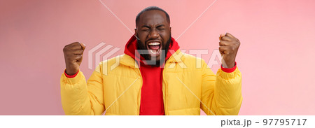 Handsome african-american man encouraging himself put will effort clenched arms yelling close eyes raise hands boost confidence, standing pink background express rage release emotions Handsome african-american man encouraging himself put will effort clenched arms yelling close eyes raise hands boost confidence, standing pink background express rage release emotions 97795717