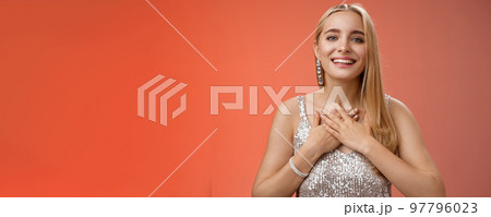 Grateful charming blond european 25s woman in silver party dress press palms heart feel thankful appreciate effort cherish romantic gesture receive flattering compliments gifts, smiling happily Grateful charming blond european 25s woman in silver party dress press palms heart feel thankful appreciate effort cherish romantic gesture receive flattering compliments gifts, smiling happily 97796023