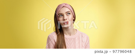 Cute pretty silly girl sharing dreams and fantazies, daydreaming, thinking about desires, speaking about what she wants, daydreaming looking at upper left corner thoughtful, folding lips amused 97796048