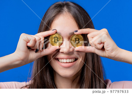 Woman with bitcoin, crypto currency. Golden coins on eyes, blue background. Digital exchange 97797633