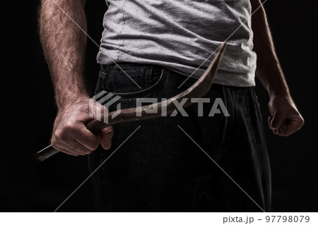 Male offender with a scrap. On black background at the studio Male offender with a scrap. On black background at the studio 97798079
