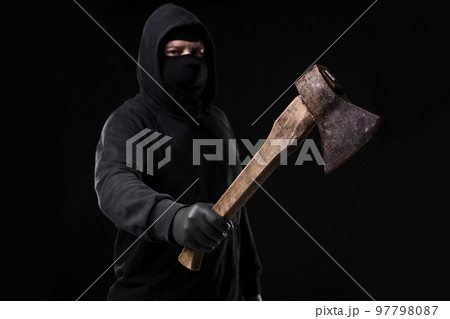 Bandit in black mask with hatchet on black background Bandit in black mask with hatchet on black background 97798087