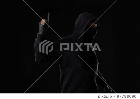 Bandit in black mask with hatchet on black background Bandit in black mask with hatchet on black background 97798090