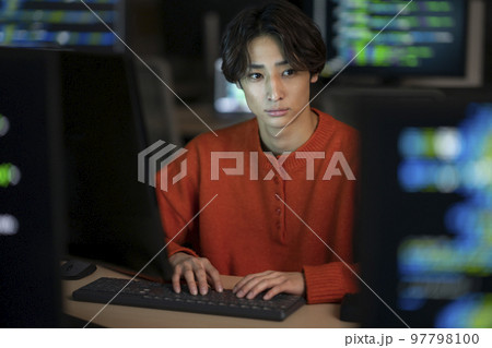 夜のオフィスでPCで作業をする若い男性　 97798100