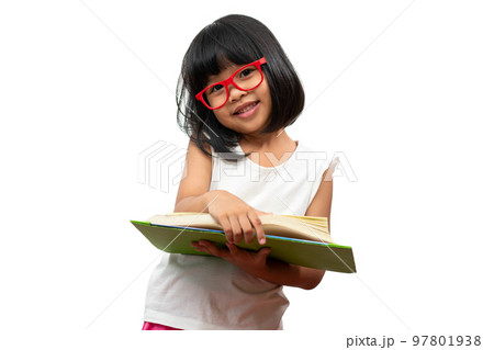 Happy Asian little preschool girl wearing red glasses holding and read a green book on white isolated background. Concept of school kid and education in elementary and preschool, home school 97801938