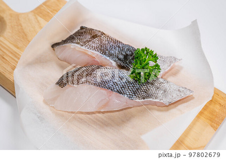 カッティングボードに乗せた真鱈の切り身 97802679