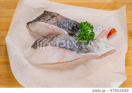 カッティングボードに乗せた真鱈の切り身 97802680