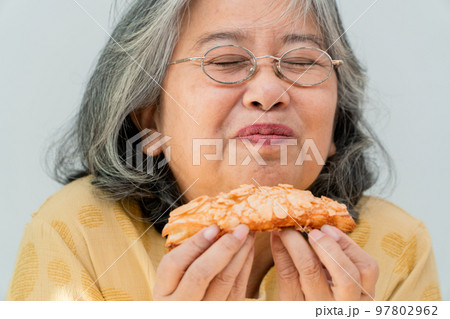 Happy Asian senior women enjoying eating pie Happy Asian senior women enjoying eating pie 97802962