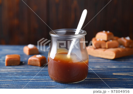 Salted caramel in jar on blue wooden table 97804956