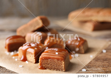 Salted caramel on wooden table, closeup view 97804957