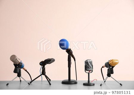 Different microphones on light grey table. Journalist's work Different microphones on light grey table. Journalist's work 97805131