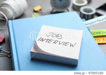 Reminder note about job interview and stationery on table, closeup 97805166