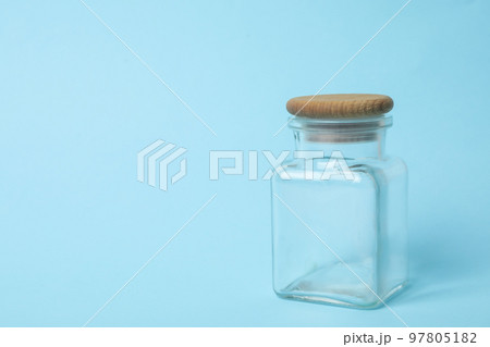 Closed empty glass jar on light blue background, space for text Closed empty glass jar on light blue background, space for text 97805182
