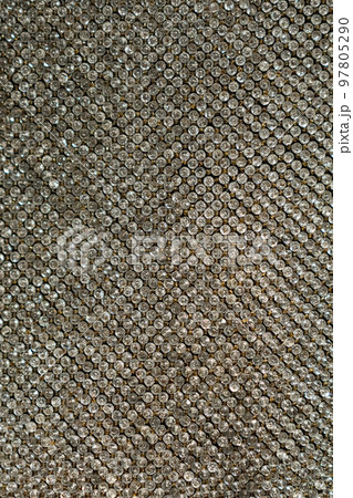 Small gemstone texture background. Background with shining elements on fabric. Holiday abstract glitter background with blinking lights. Fashion metallic 97805290